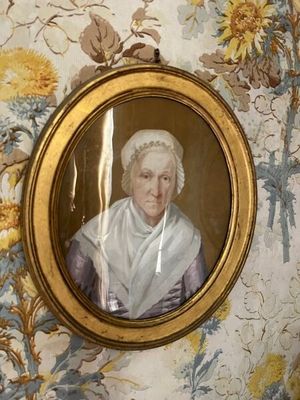 la photo d'une vieille dame dans un cadre accroché au mur