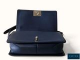 the back view of a blue leather purse with a metal clasp
