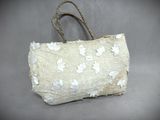 beige and white bag with white flowers on it