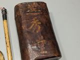 a leather case and a brush on a table