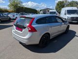 the back end of a silver car parked in a parking lot
