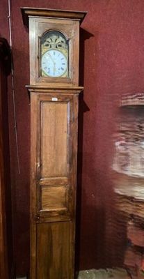 a tall wooden grandfather clock in the corner of a room