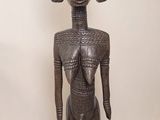 an image of a wooden statue of a woman standing on a wooden floor