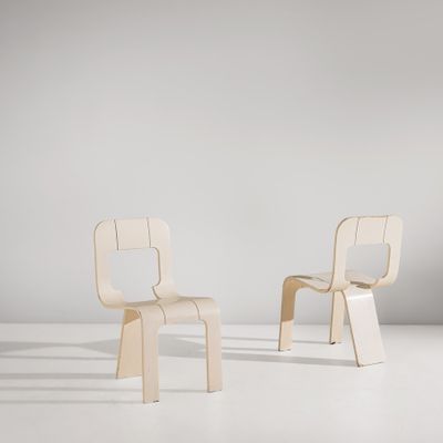 une paire de chaises en bois posées sur un sol blanc