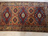 an old rug with a red, blue, and yellow design on it