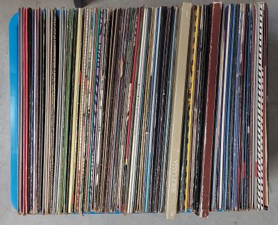 une pile de disques posée sur une table, à côté d'une paire de ciseaux