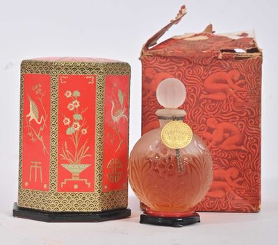 un flacon de parfum posé à côté d'une boîte sur une table