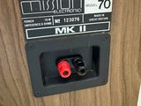 a close up of a wooden speaker with a red knob