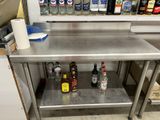 a stainless steel table with bottles of alcohol on it