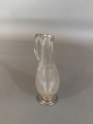 un pichet en verre posé sur une table, sur fond blanc