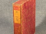 a red book sitting on top of a gray surface