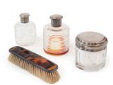 three bottles and a brush on a white surface