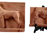 deux sculptures en argile représentant un chien et un chien sur un socle
