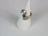a close up of a ring with a green stone on it