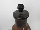 a brown vase with a black lid on a white table