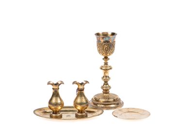 une assiette en argent avec une coupe en or et une assiette en argent sur laquelle repose une pièce de monnaie