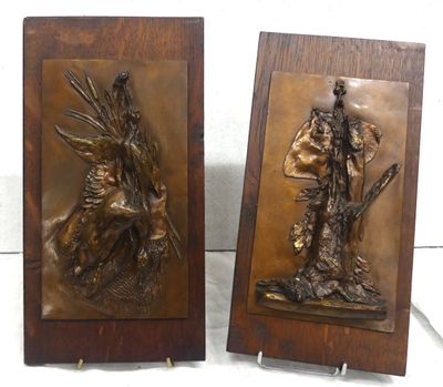 pair of bronze sculptures of a man and a woman on a horse