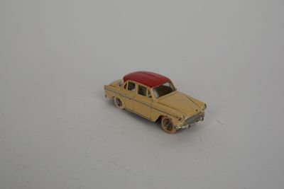 une petite voiture jaune avec un toit rouge posée sur une surface blanche