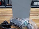 a laptop computer sitting on a wooden table next to a charger
