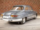 a silver car that is parked in front of a brick wall