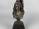 a bronze bust of a woman holding a flag on a black base