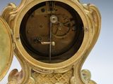 a gold clock that is sitting on top of a table