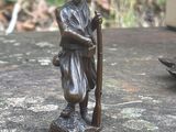 une statue représentant un homme tenant un fusil, debout sur un rocher