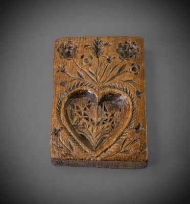 une vieille plaque en bois sur laquelle est sculpté un cœur