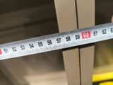 someone is measuring the height of a piece of wood with a ruler