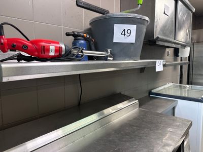 une étagère en métal sur laquelle est posé un seau, dans une cuisine