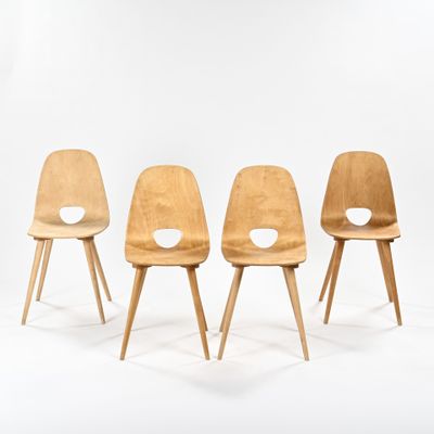 four wooden chairs with holes in the back of them on a white background