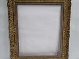 an old picture frame with a white background and gold trim
