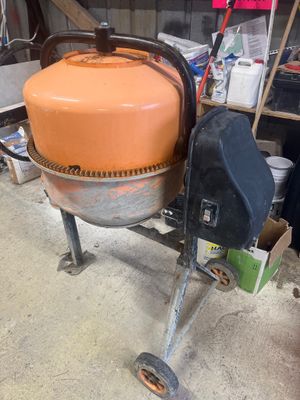 une bétonnière posée sur un chariot dans un garage