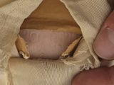 a hand holding a piece of cloth with a hole in it