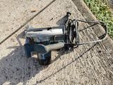 a corded drill on the ground next to a power cord