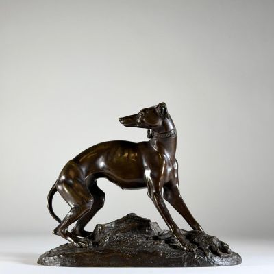 statue en bronze d'un chien sur un rocher sur fond blanc