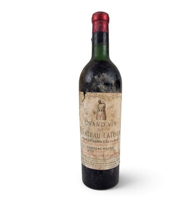 une vieille bouteille de vin posée sur une surface blanche