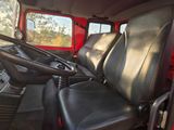 a red truck with two black seats and a steering wheel