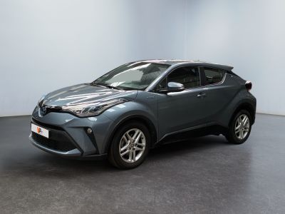 un SUV Toyota C-HR gris garé dans une pièce blanche