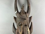 an image of a wooden mask with horns on a white background