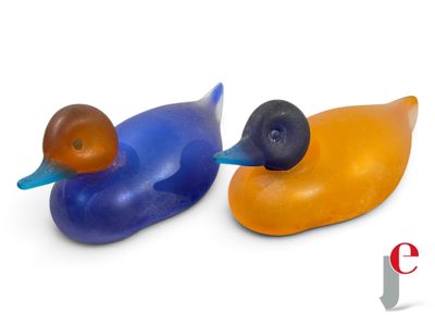 two plastic ducks sitting next to each other on a white surface