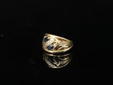 une image d'une bague en or avec une pierre bleue au centre