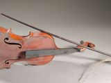 un vieux violon posé sur une table, à côté d'une corde