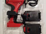 a red corded drill and two batteries in a package
