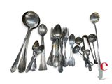 a lot of silver spoons and spoons on the table