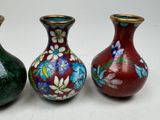 three vases are sitting side by side on a white surface