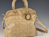 sac à main en cuir beige avec des finitions et des anses dorées sur fond gris