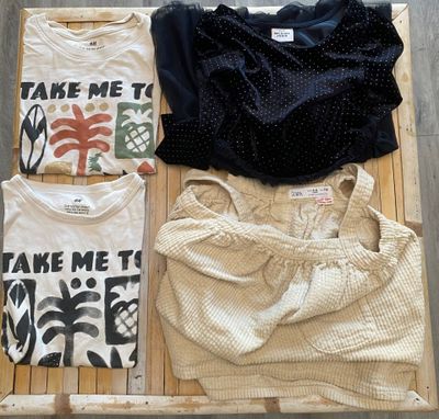 trois t-shirts posés sur une caisse en bois