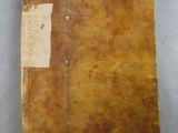 an old book with a tag on it sitting on a table