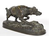 statue en bronze représentant un chien courant sur un rocher, sur fond blanc